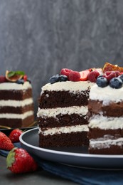 Delicious chocolate sponge cake with berries on table, closeup