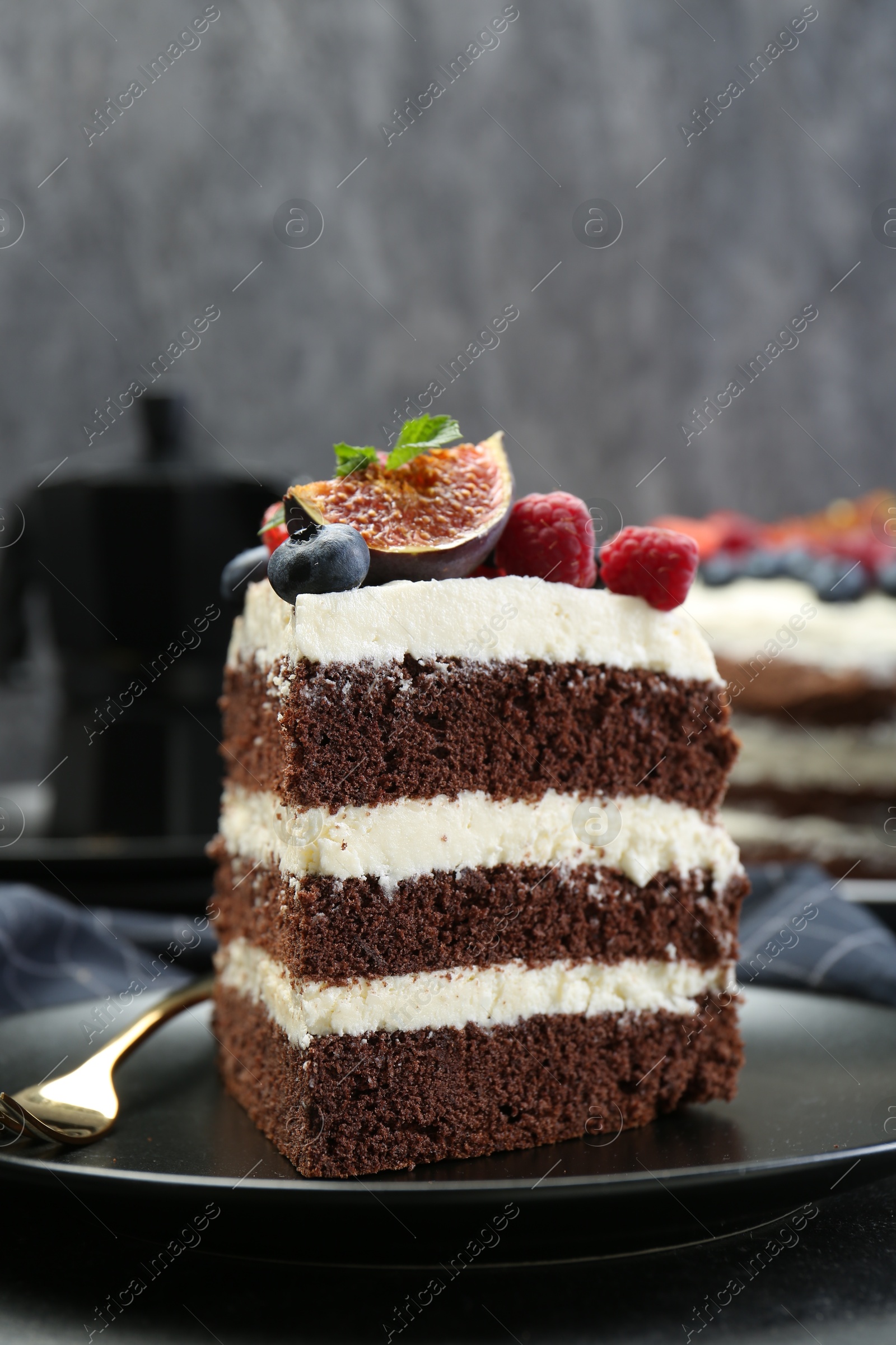 Photo of Piece of delicious chocolate sponge cake with berries on table, closeup