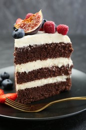 Photo of Piece of delicious chocolate sponge cake with berries on table, closeup