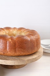 Photo of Freshly baked sponge cake on white wooden table, closeup