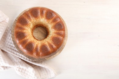 Photo of Freshly baked sponge cake on white wooden table, top view. Space for text