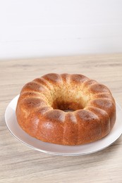 Photo of Freshly baked sponge cake on wooden table