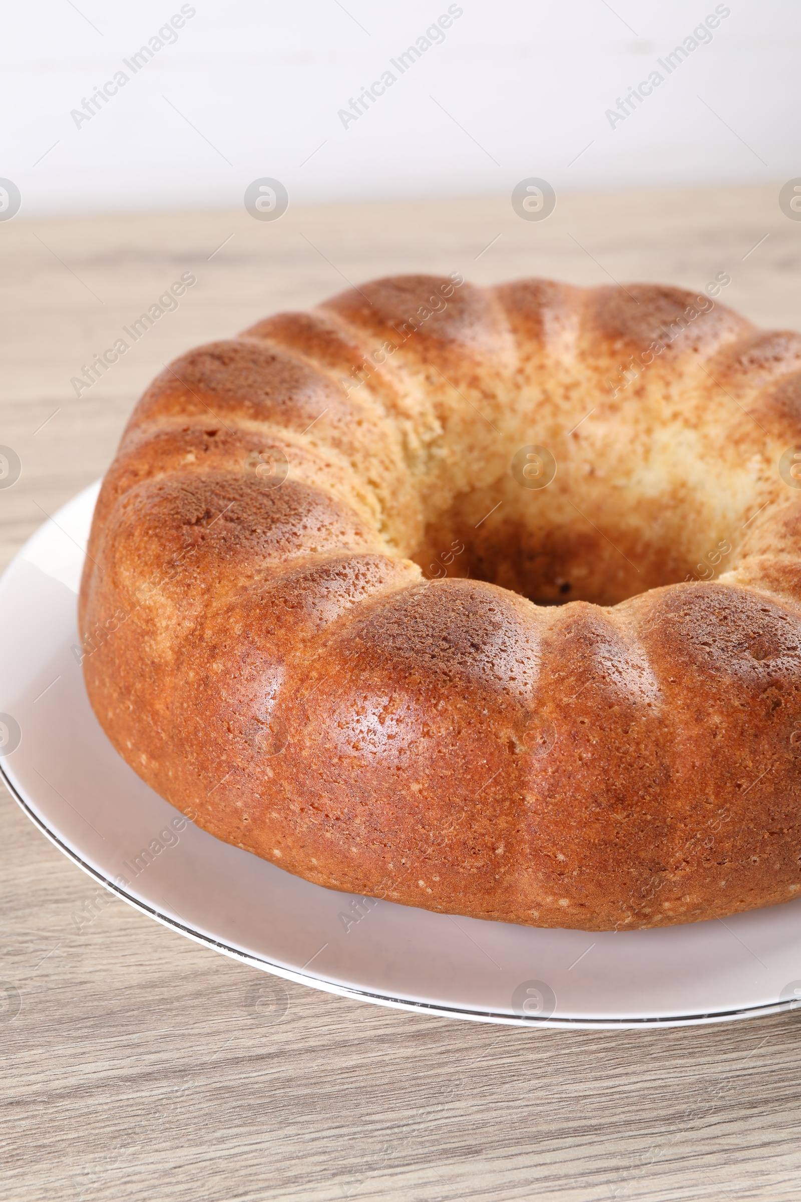 Photo of Freshly baked sponge cake on wooden table, closeup