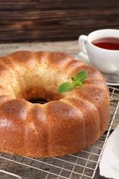 Freshly baked sponge cake and tea on wooden table, closeup