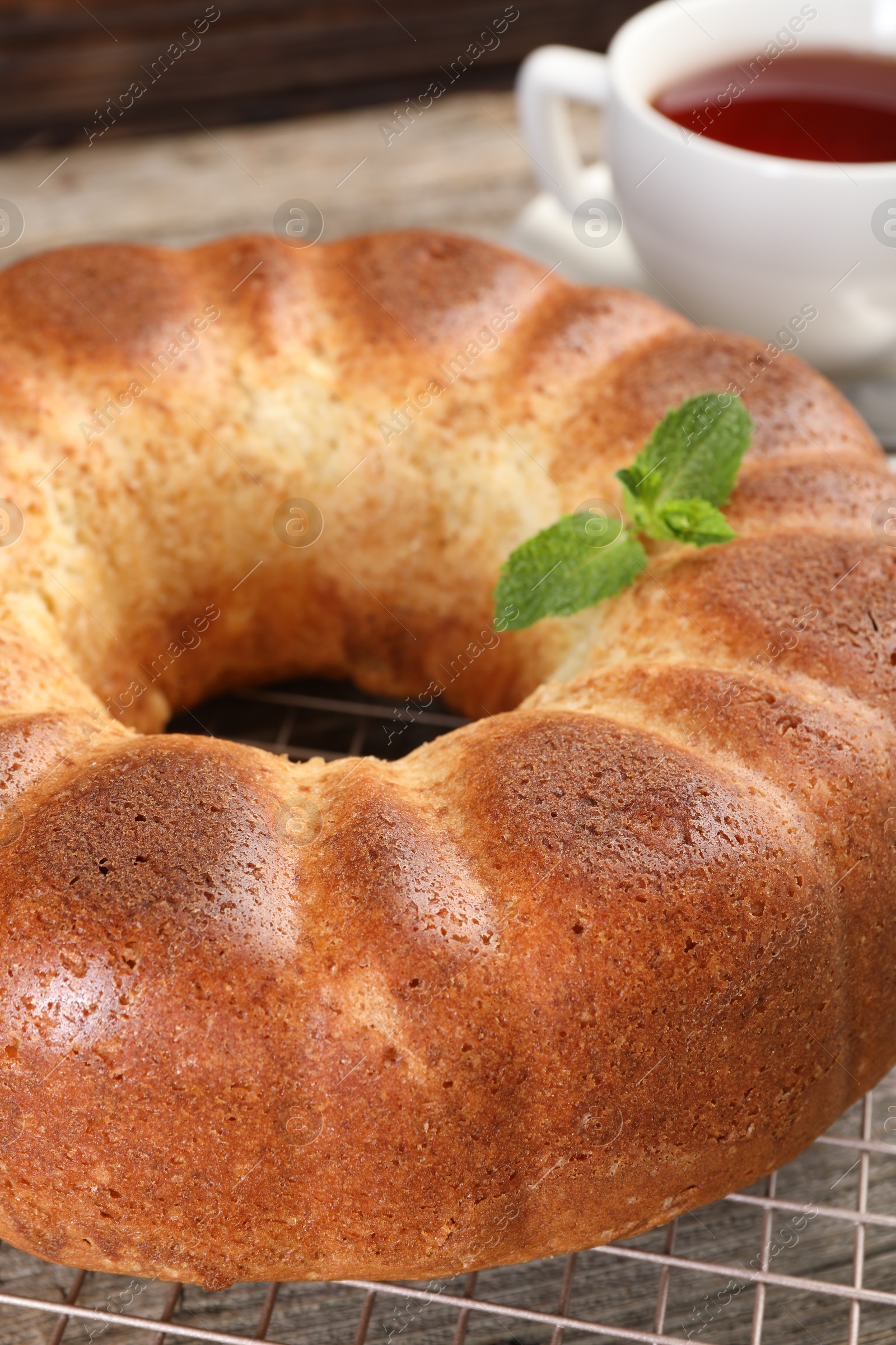 Photo of Freshly baked sponge cake and tea on table, closeup