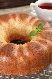 Photo of Freshly baked sponge cake and tea on table, closeup