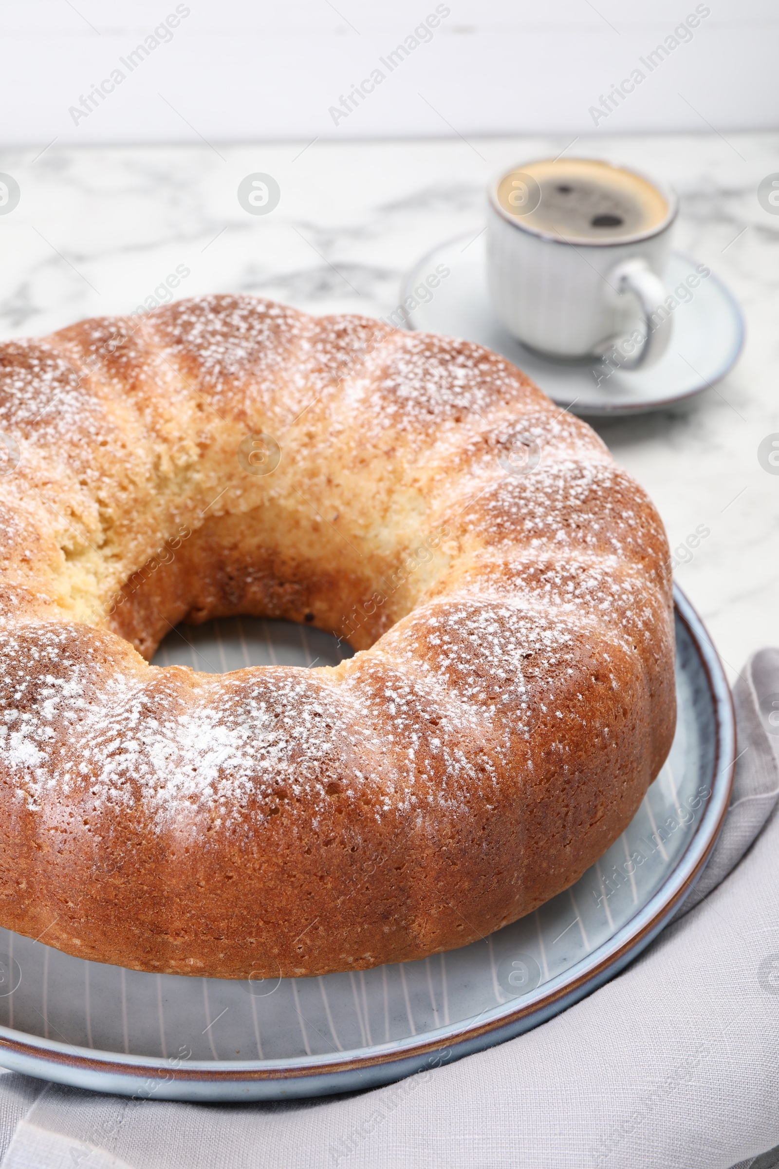 Photo of Freshly baked sponge cake and coffee on white marble table, closeup