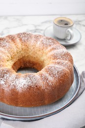 Freshly baked sponge cake and coffee on white marble table, closeup