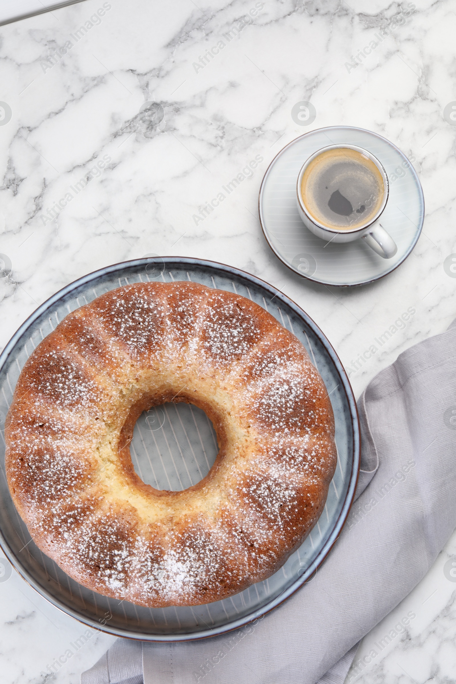 Photo of Freshly baked sponge cake and coffee on white marble table, top view