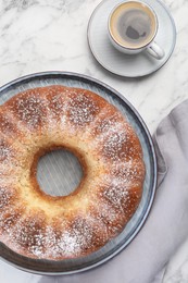 Freshly baked sponge cake and coffee on white marble table, top view