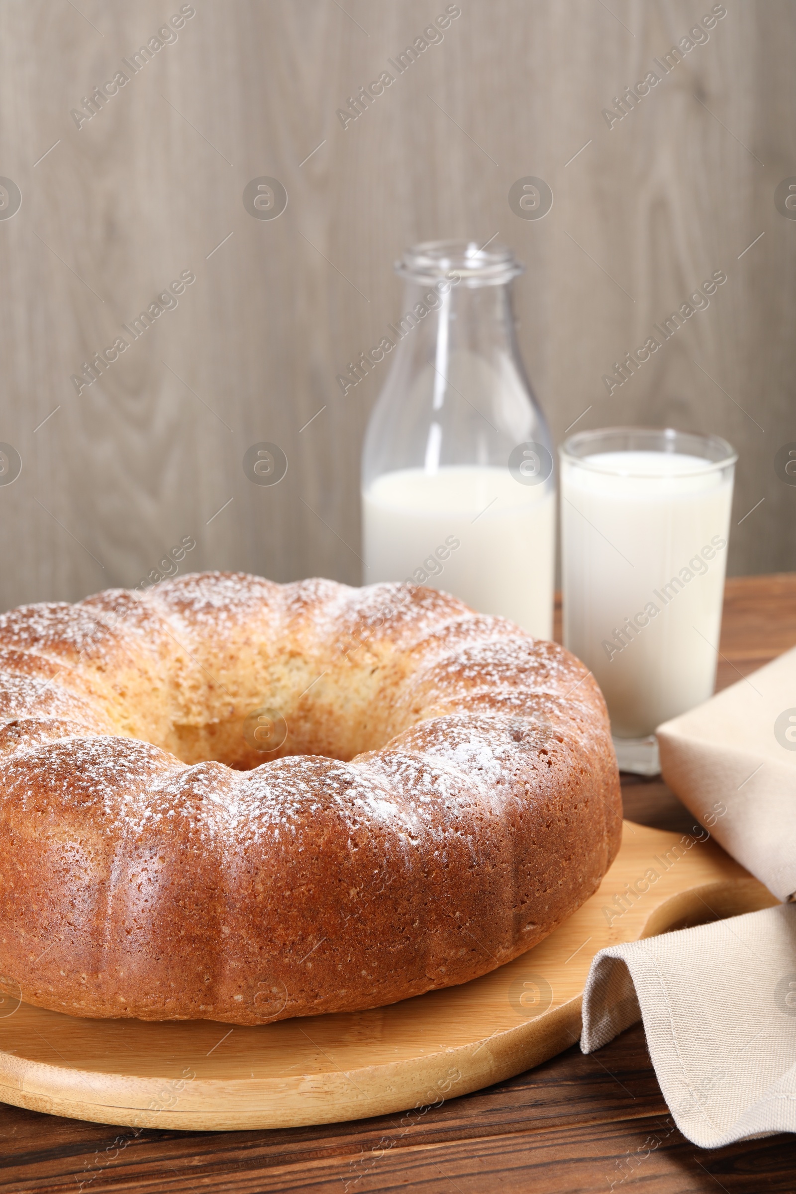 Photo of Freshly baked sponge cake and milk on wooden table, closeup