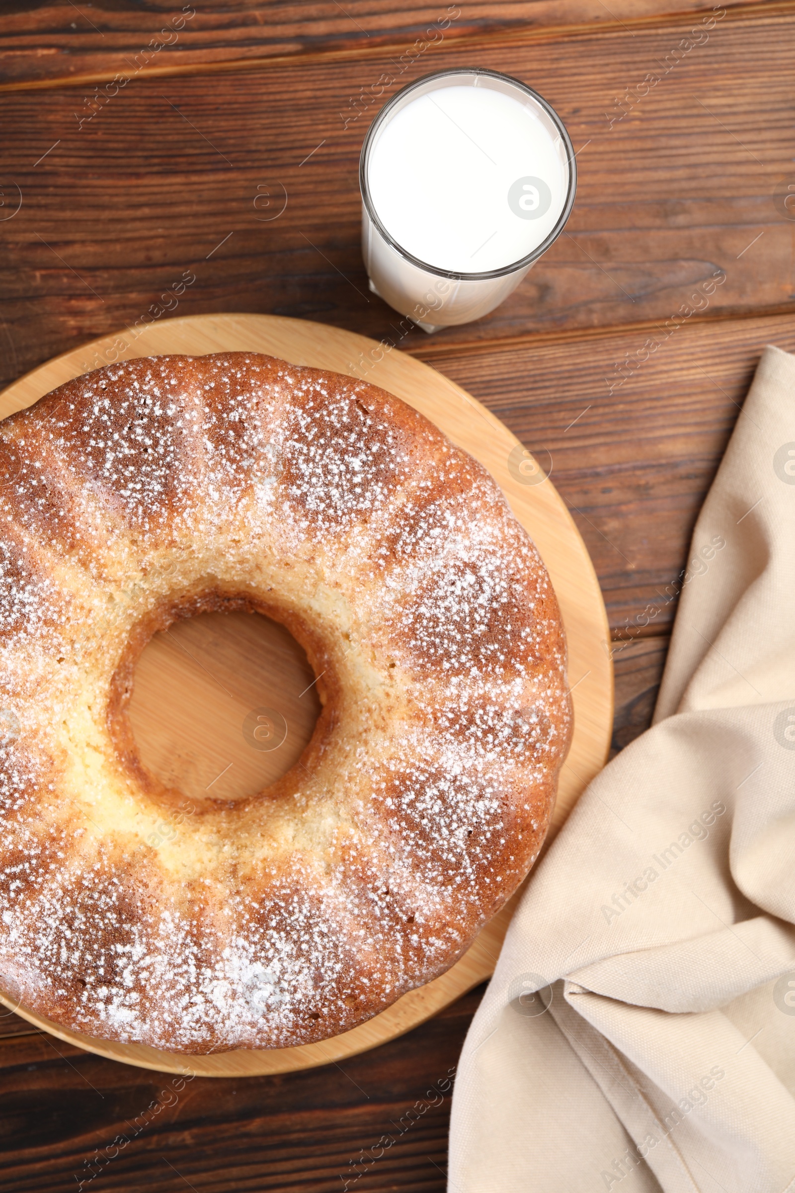 Photo of Freshly baked sponge cake and milk on wooden table, top view