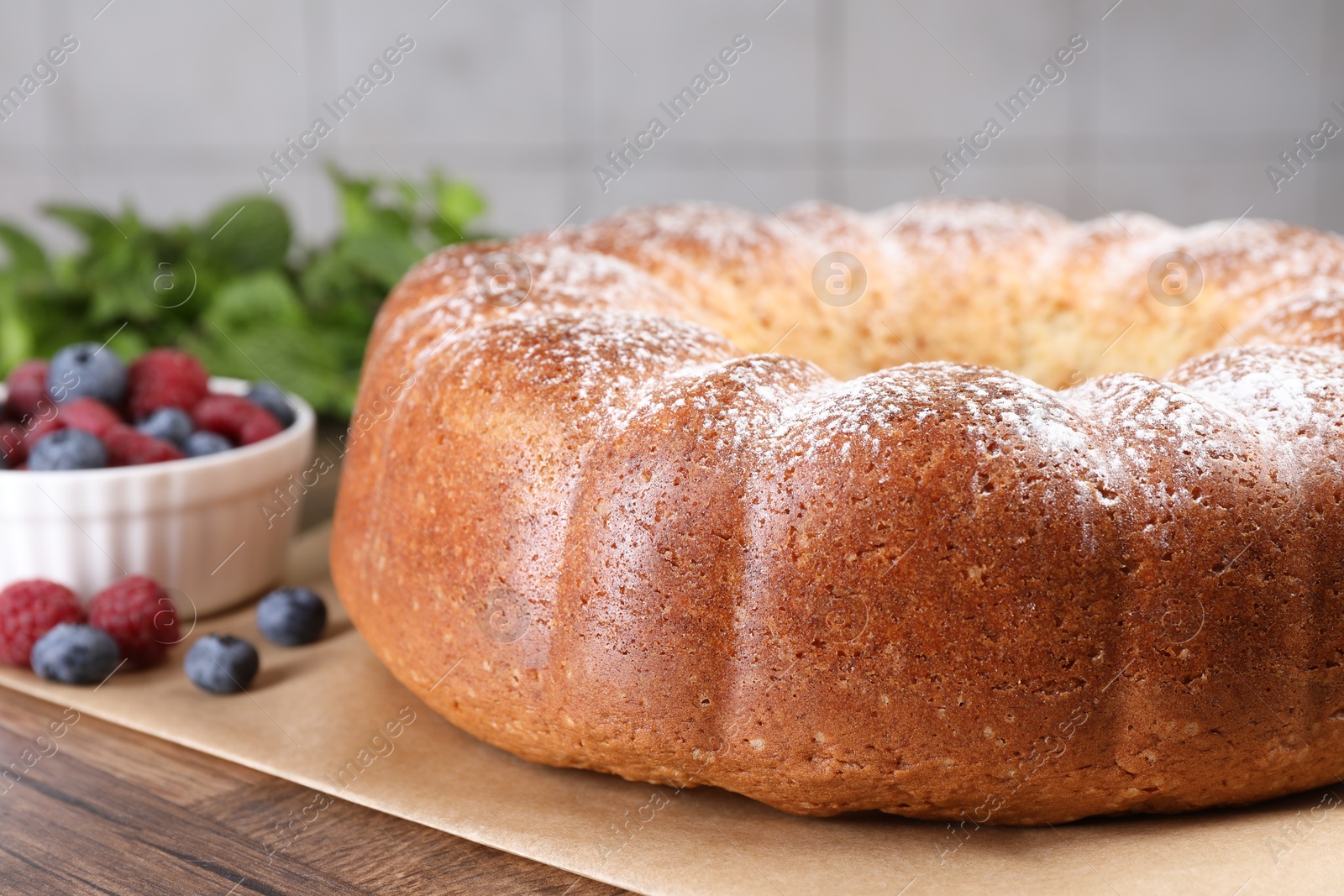 Photo of Freshly baked sponge cake and berries on wooden table, closeup