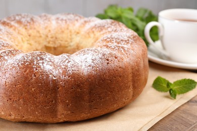 Freshly baked sponge cake and mint on wooden table, closeup