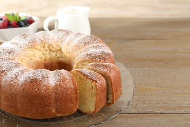 Freshly baked sponge cake, milk and berries on wooden table, closeup