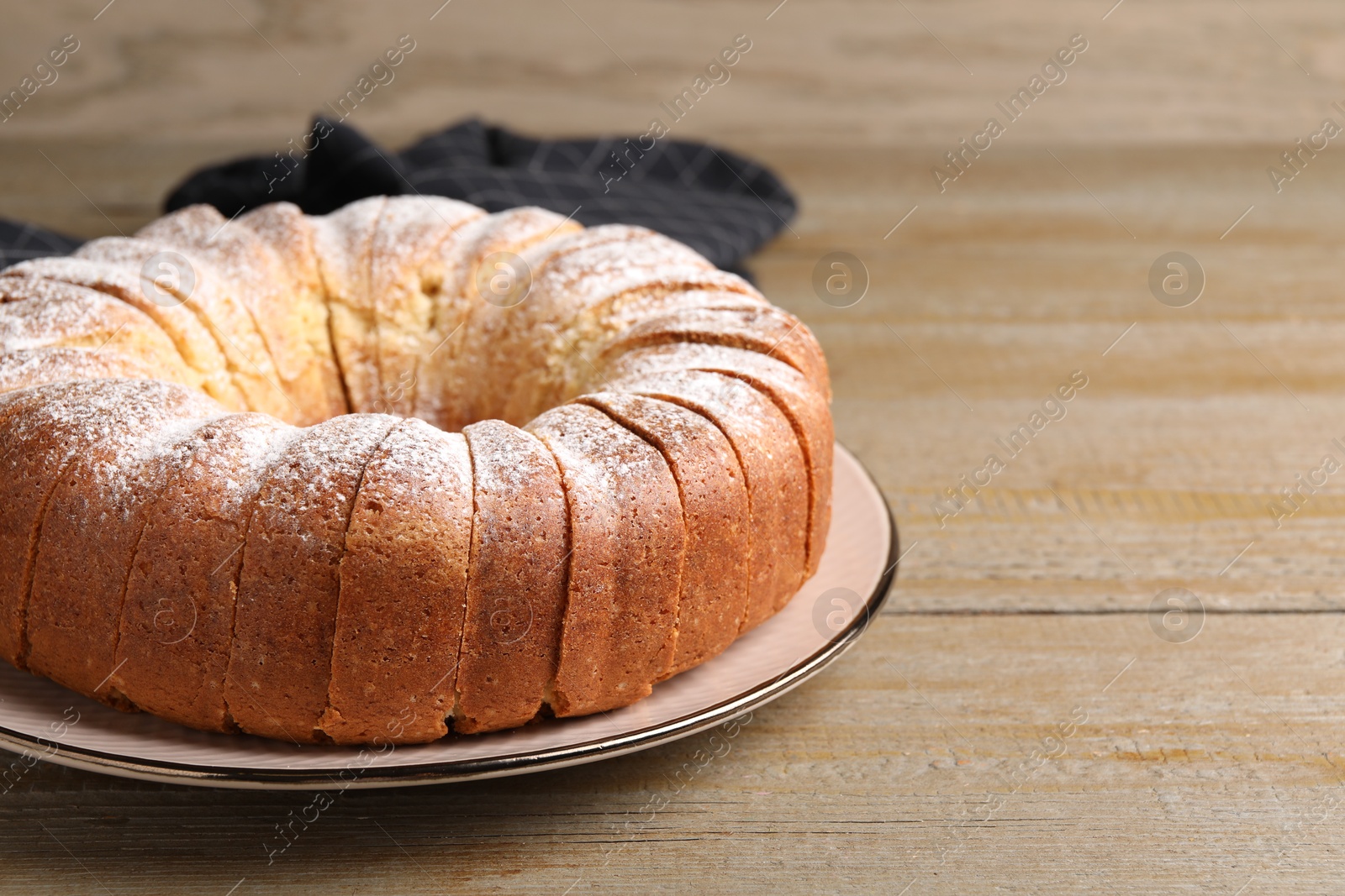 Photo of Freshly baked sponge cake on wooden table, closeup. Space for text