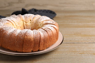 Freshly baked sponge cake on wooden table, closeup. Space for text