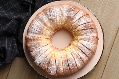 Freshly baked sponge cake on wooden table, top view