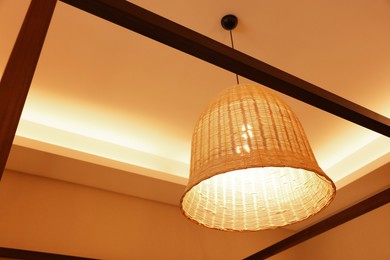 Photo of Stylish pendant lamp on ceiling indoors, low angle view