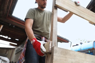 Man working with wooden planks outdoors, closeup