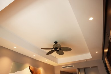 Photo of Modern ceiling fan indoors, low angle view