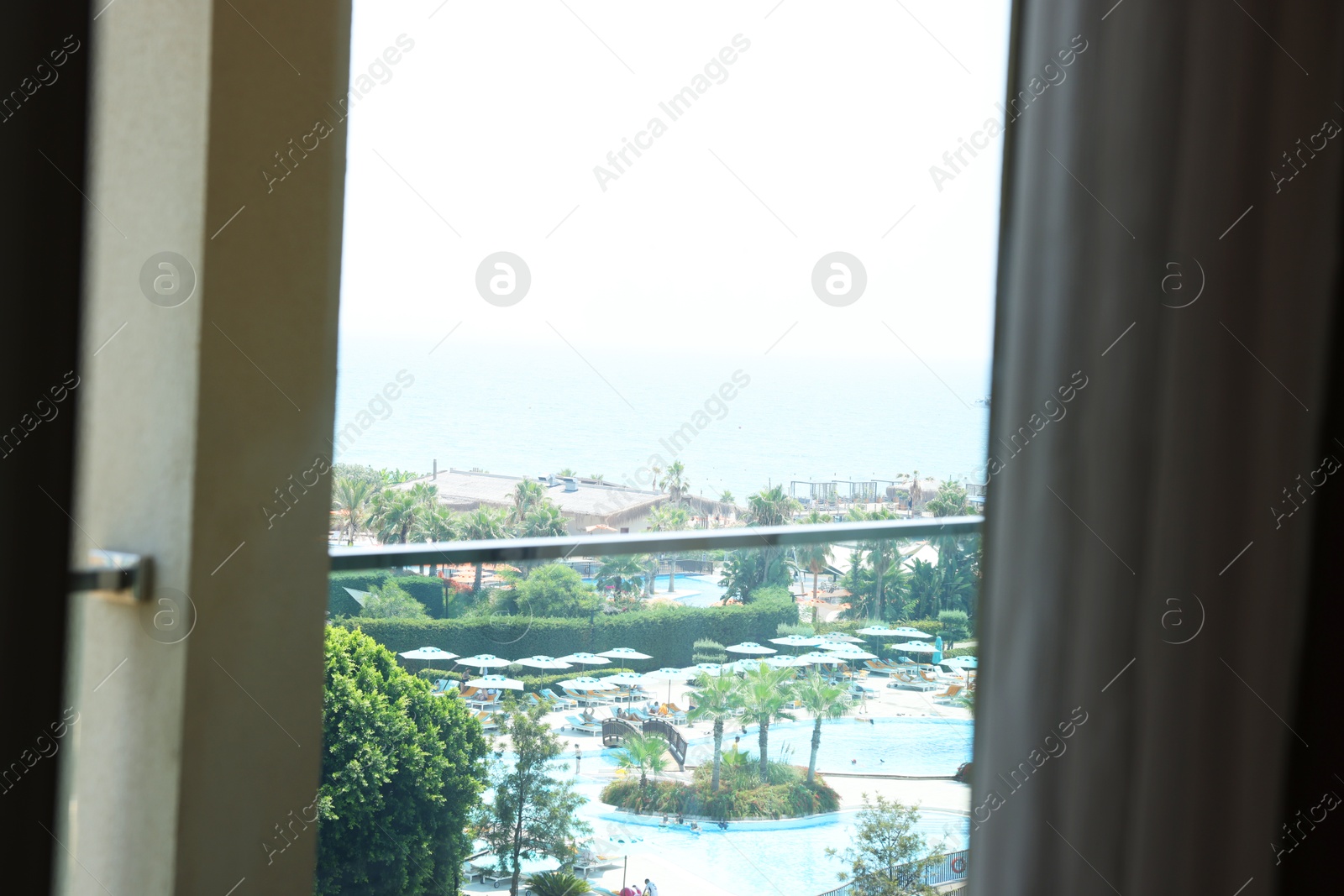 Photo of Beautiful view on luxury resort through glass window from hotel room