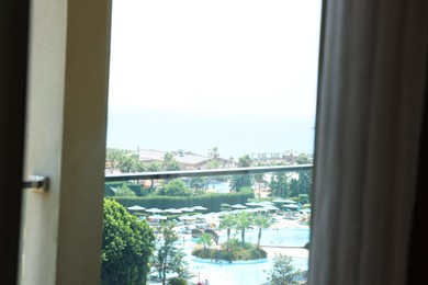 Beautiful view on luxury resort through glass window from hotel room