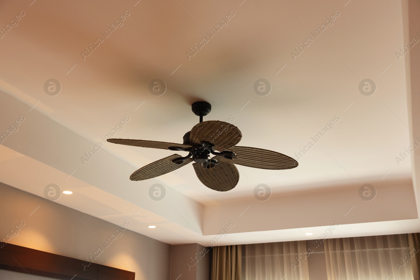 Photo of Modern ceiling fan indoors, low angle view