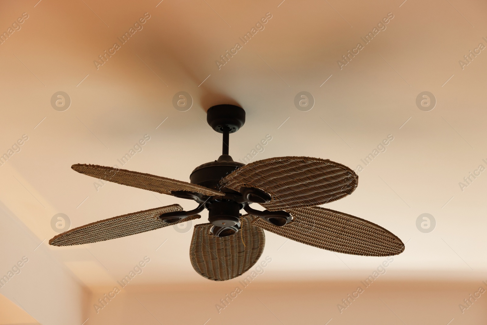 Photo of Modern ceiling fan indoors, low angle view