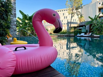 Outdoor swimming pool with clear water and inflatable float in shape of flamingo at luxury resort