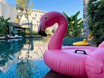 Photo of Outdoor swimming pool with clear water and inflatable float in shape of flamingo at luxury resort