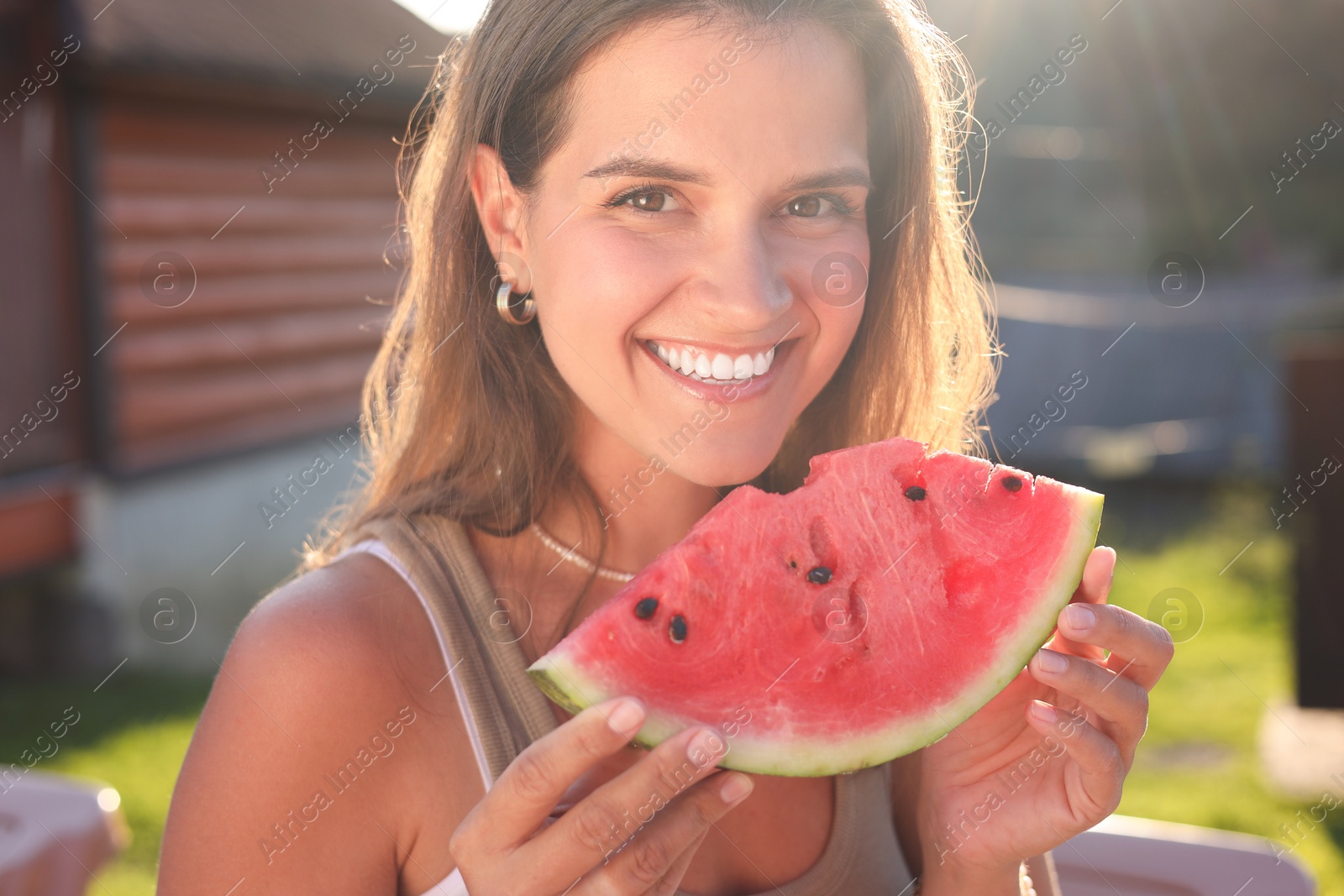 Photo of Happy woman with slice of juicy watermelon outdoors