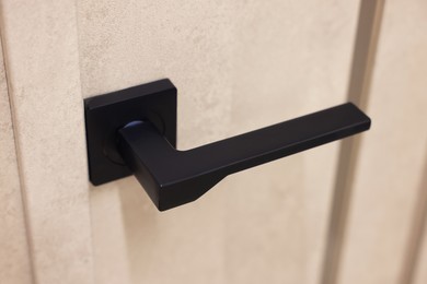 Photo of Beige door with black handle, closeup view