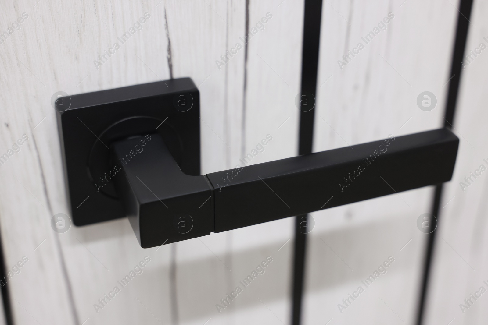 Photo of Wooden door with black handle, closeup view