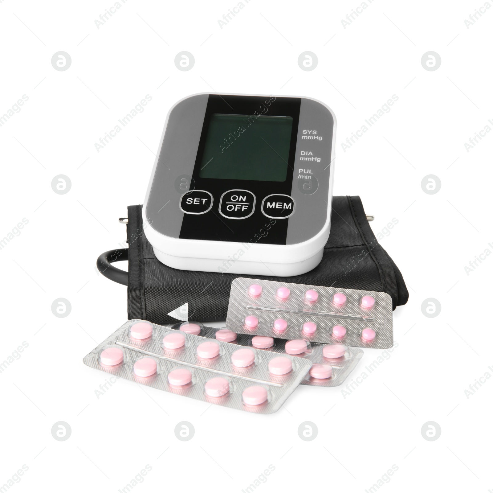 Photo of Blood pressure monitor and pills in blisters isolated on white