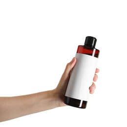 Woman with shampoo bottle on white background, closeup