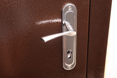 Photo of View of door with modern metal handle, closeup