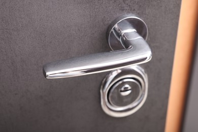 Photo of View of door with modern metal handle, closeup