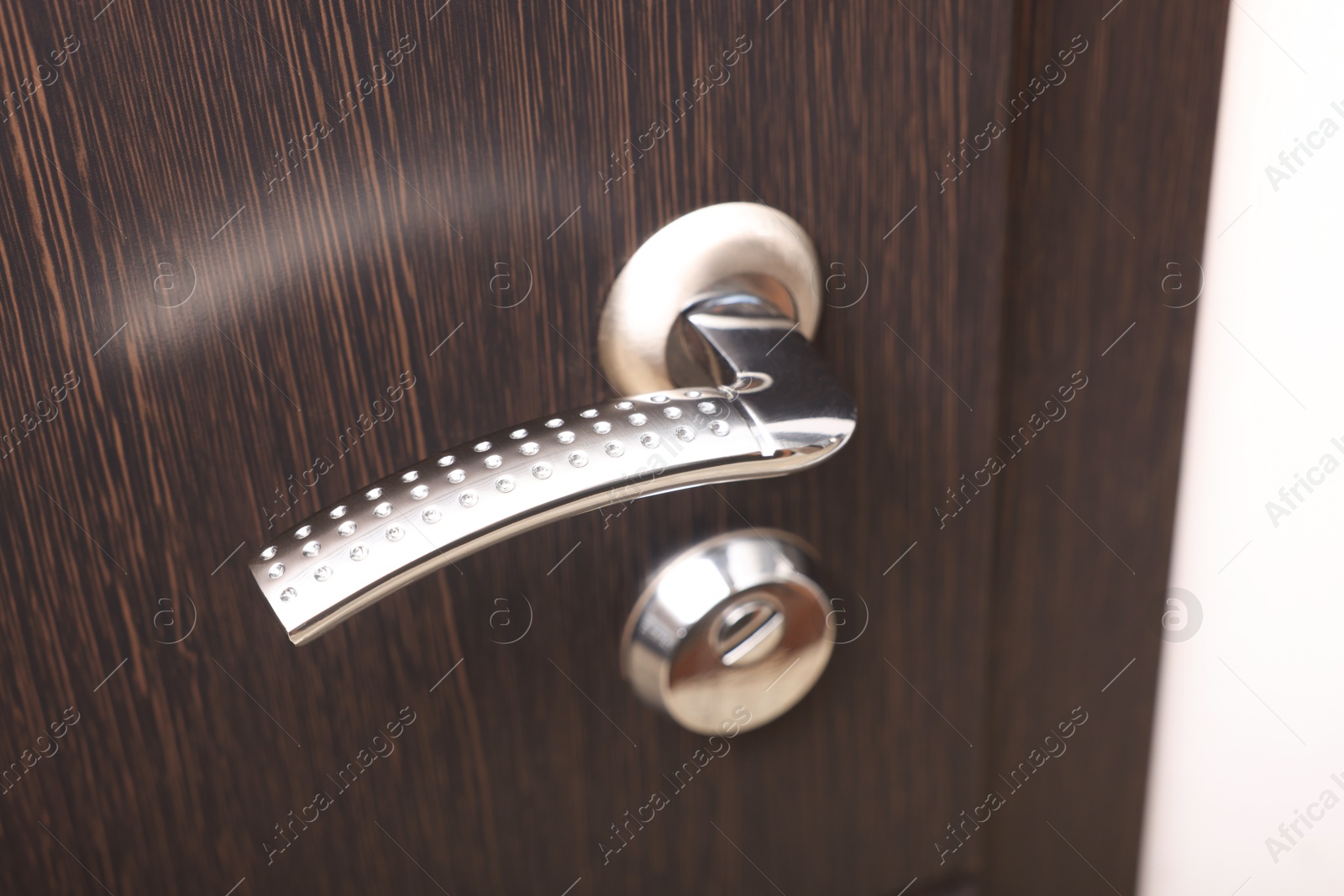 Photo of View of door with modern metal handle, closeup