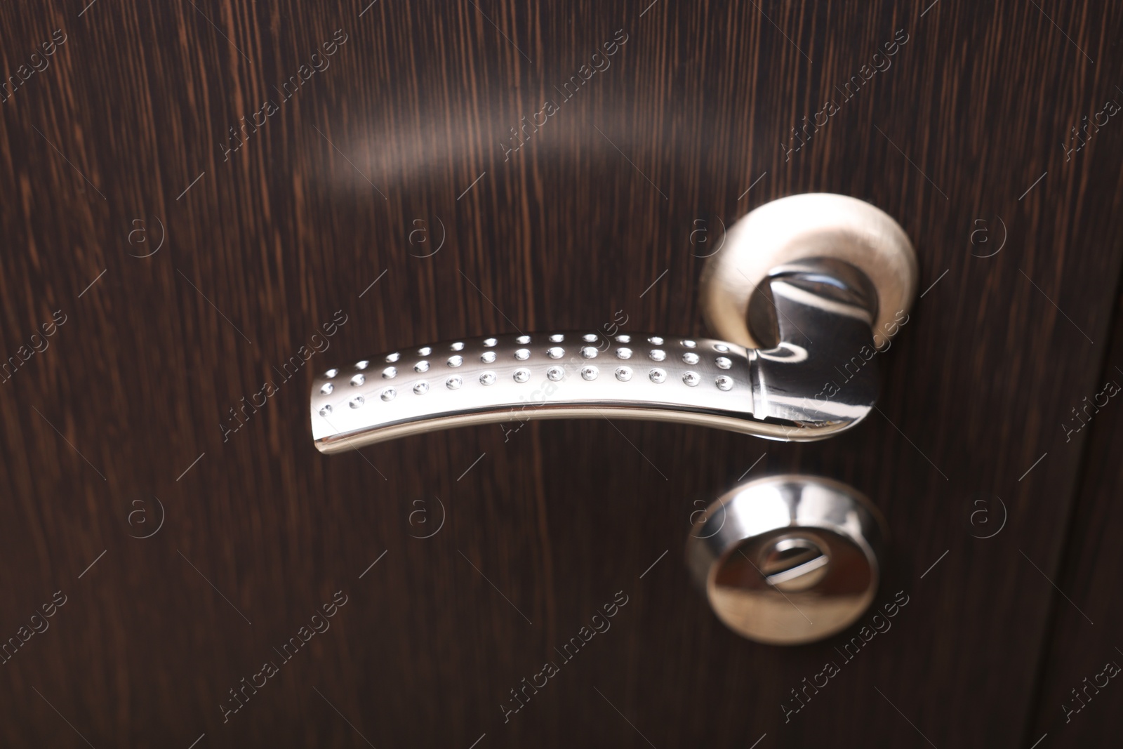 Photo of View of door with modern metal handle, closeup