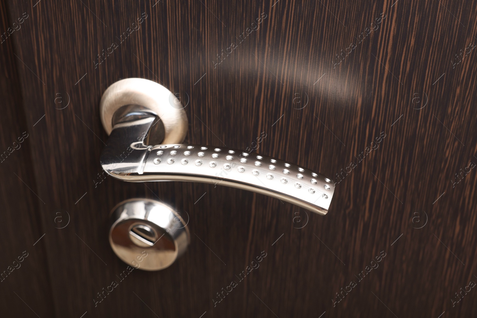 Photo of View of door with modern metal handle, closeup