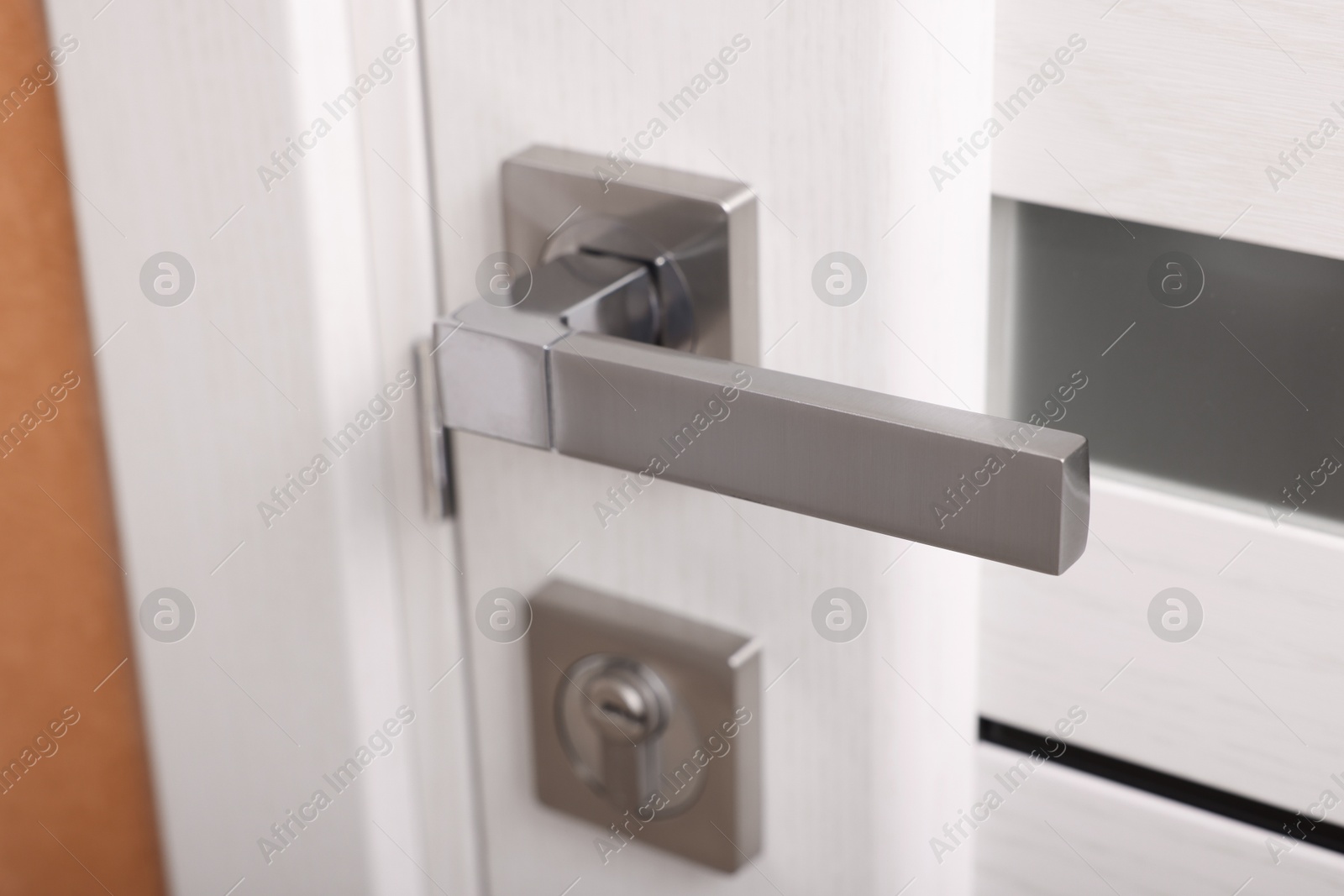 Photo of View of door with modern metal handle, closeup