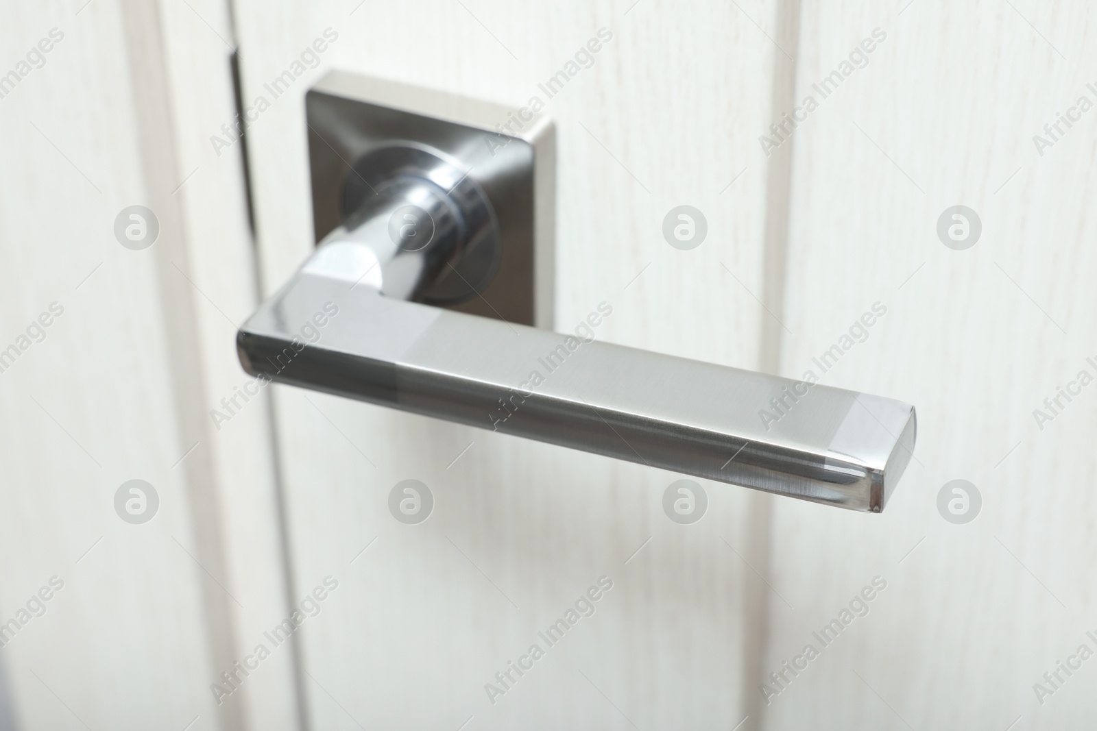 Photo of View of door with modern metal handle, closeup