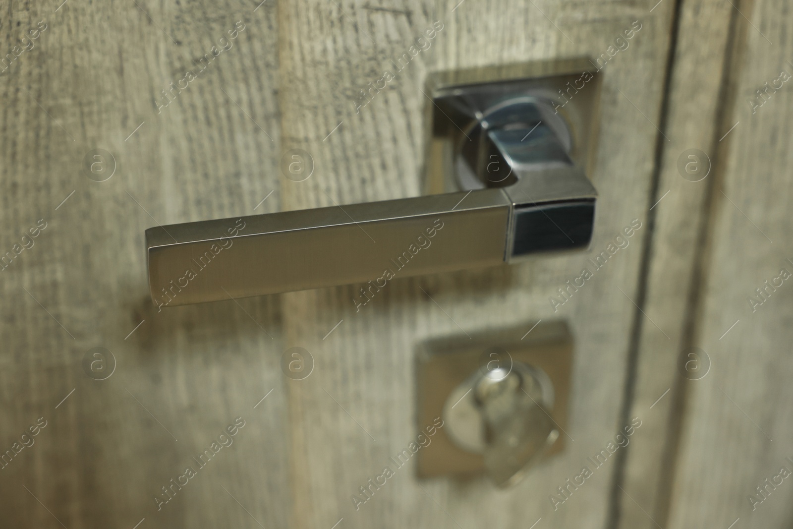 Photo of View of door with modern metal handle, closeup