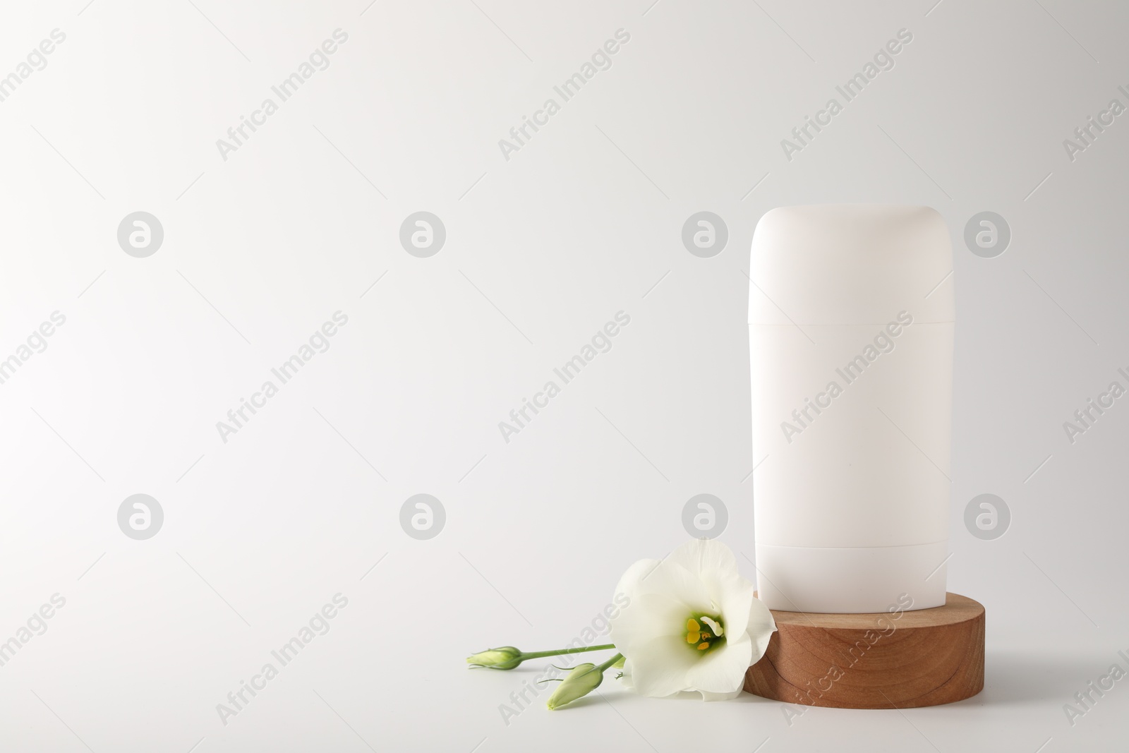 Photo of Solid deodorant and beautiful eustoma flower on white background, space for text