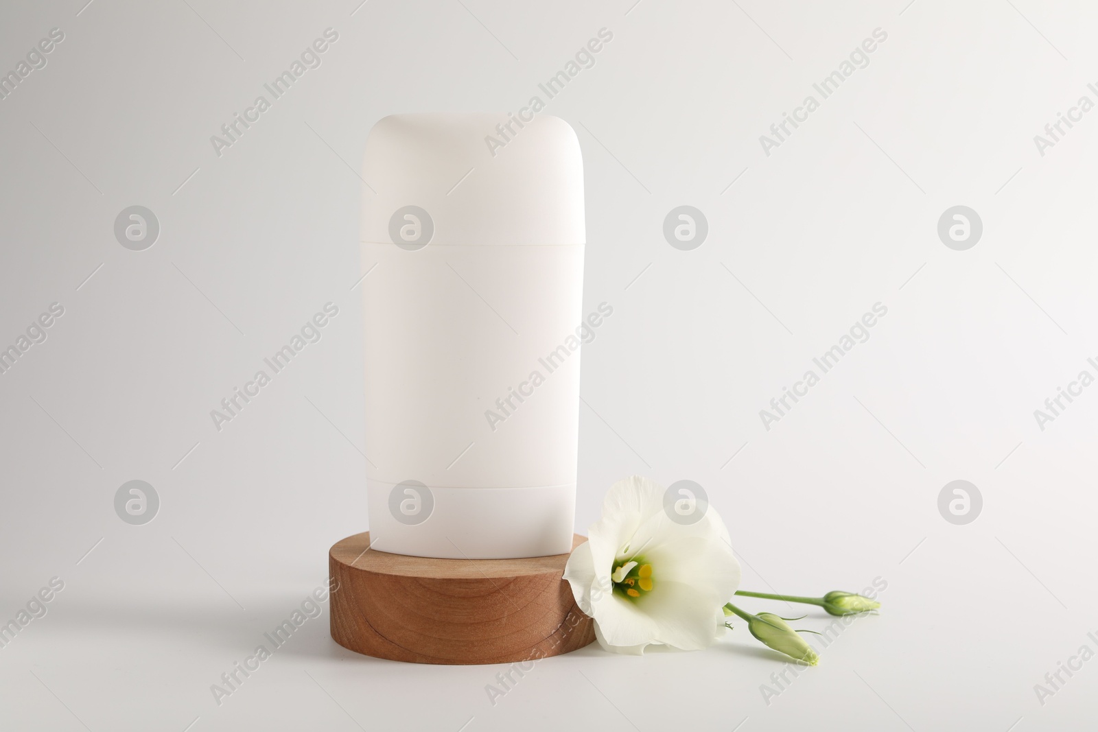 Photo of Solid deodorant and beautiful eustoma flower on white background