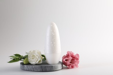 Photo of Roll-on deodorant and beautiful eustoma flowers on white background