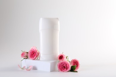 Photo of Solid deodorant and beautiful rose flowers on white background