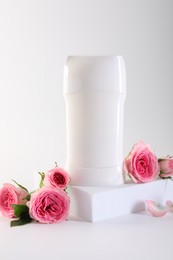 Photo of Solid deodorant and beautiful rose flowers on white background