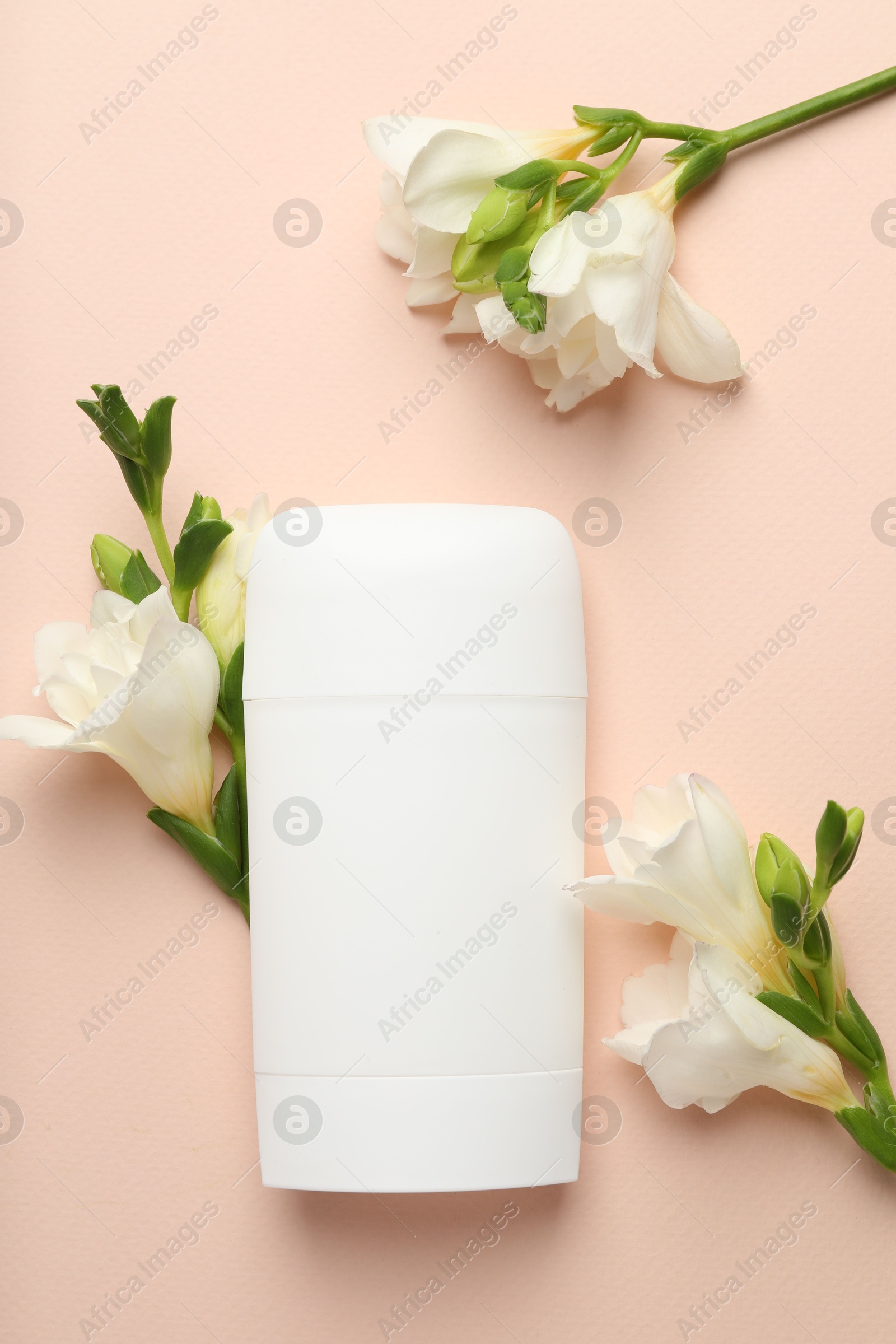 Photo of Solid deodorant and beautiful eustoma flowers on beige background, flat lay